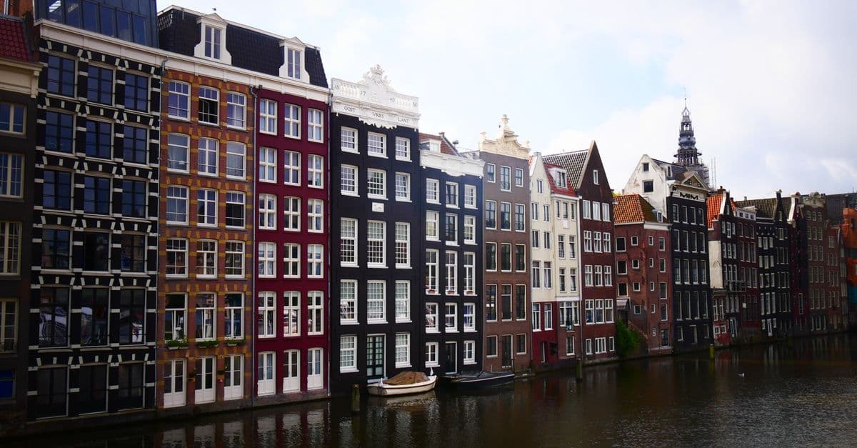 Historic canal houses reflected in the water in Amsterdam