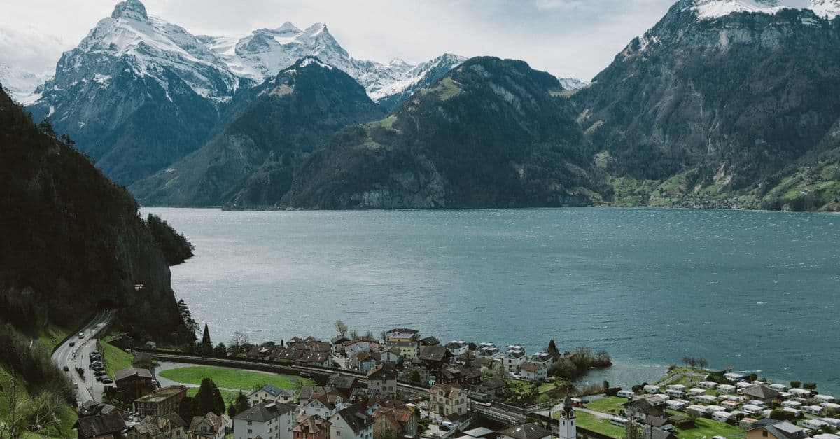 Village on the shore of Lake Lucerne with snow-capped Swiss Alps